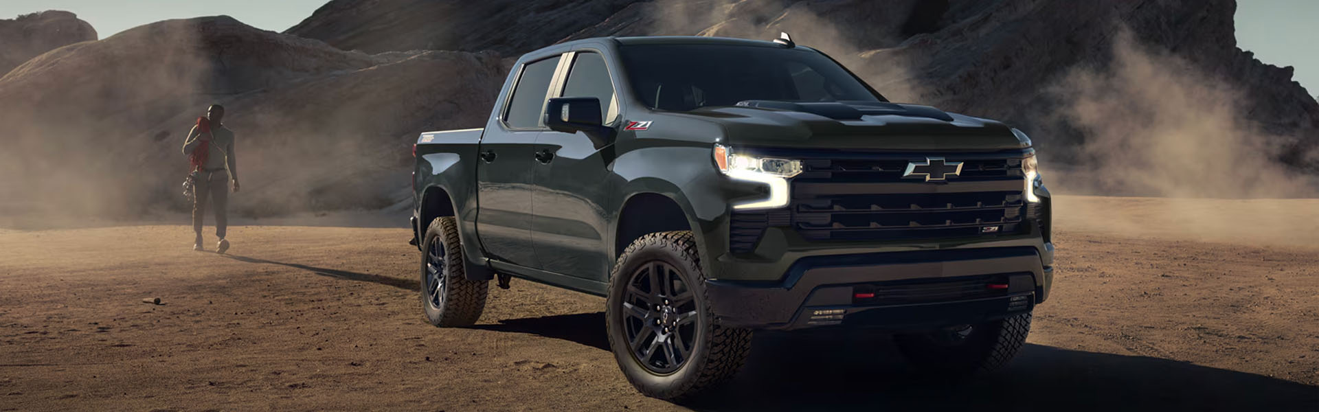 Black Chevrolet Silverado truck in desert terrain.